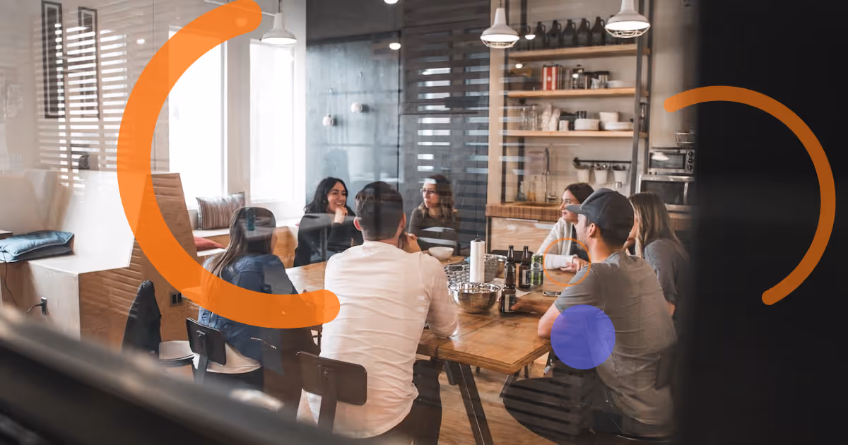 Colleagues paired randomly for a coffee roulette meeting, chatting and laughing over drinks.