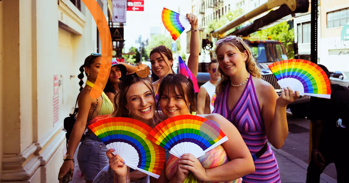 Personas sonrientes con abanicos arcoíris, símbolo de la inclusión LGBTQ+