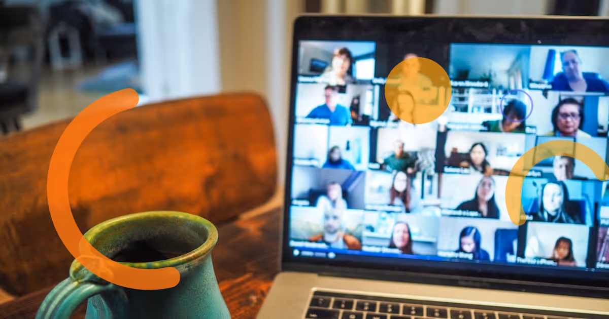 Two colleagues having a virtual coffee chat on a video call, smiling and connecting informally.