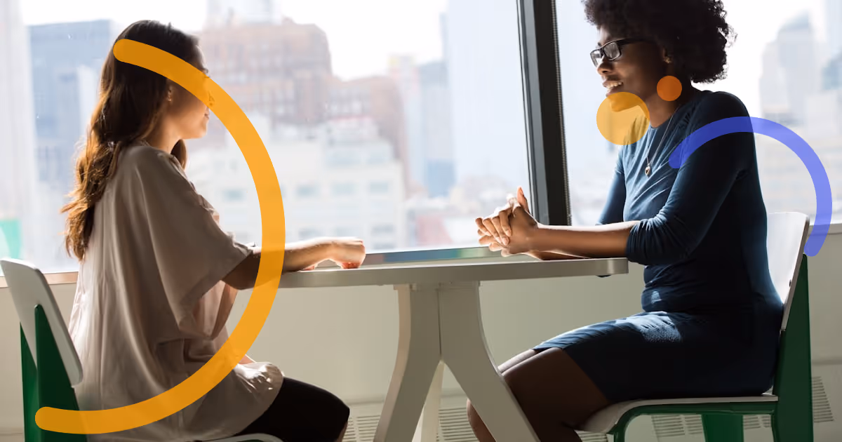 Two colleagues in a mentoring conversation, sharing knowledge and building professional connection.